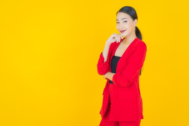 Retrato linda jovem asiática sorrindo com ação em amarelo