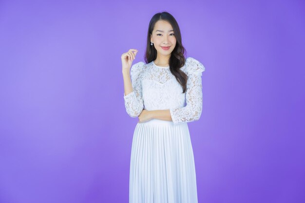 Retrato linda jovem asiática sorrindo com ação na cor de fundo