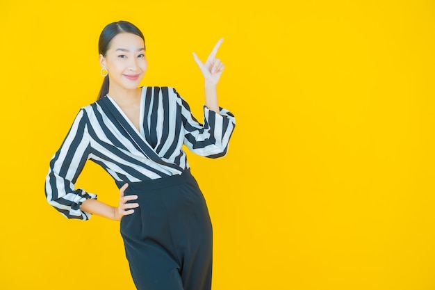 Retrato linda jovem asiática sorrindo em amarelo