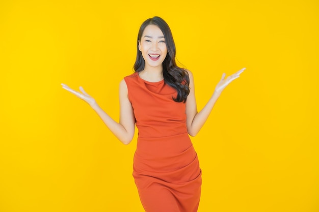 Retrato linda jovem asiática sorrindo em amarelo