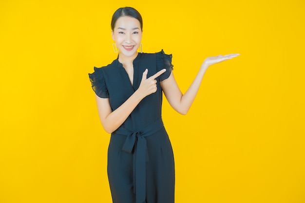 Retrato linda jovem asiática sorrindo em amarelo