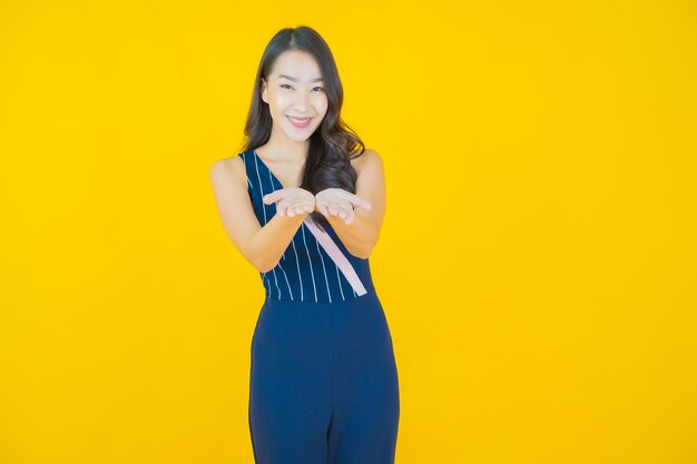 Retrato linda jovem asiática sorrindo em amarelo