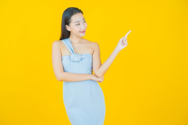 Retrato linda jovem asiática sorrindo em amarelo