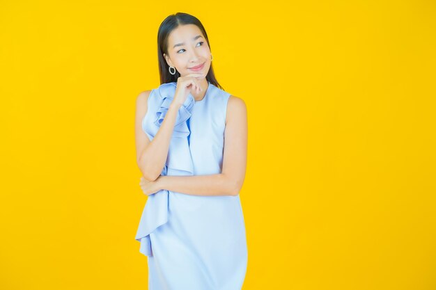 Retrato linda jovem asiática sorrindo em amarelo