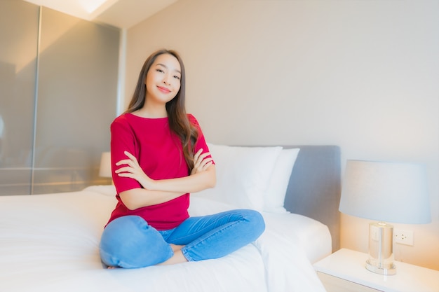 Retrato linda jovem asiática sorrindo relaxando na cama