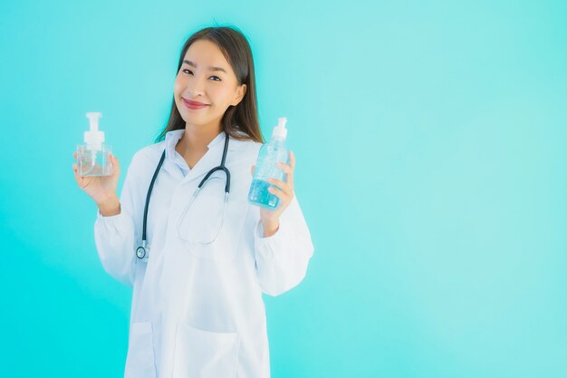 Retrato linda jovem médico asiático mulher com álcool gel para mão limpa