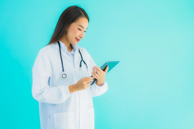 Retrato linda jovem médico asiático mulher com estetoscópio e tablet inteligente