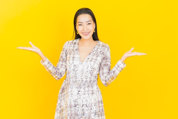 Retrato lindo jovem asiático sorrindo posando em amarelo