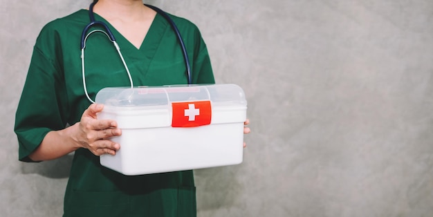 Retrato médico de mulher asiática vestindo uniforme carregando kit de caixa de primeiros socorros com fundo de espaço de cópia