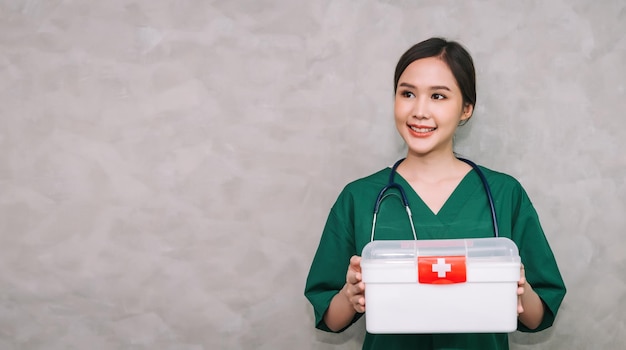 Retrato médico de mulher asiática vestindo uniforme carregando kit de caixa de primeiros socorros com fundo de espaço de cópia