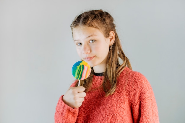 Retrato, menina, segurando, pirulito, cinzento, fundo