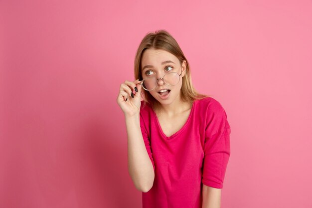 Retrato monocromático de jovem caucasiana em estúdio rosa, emotivo e bonito