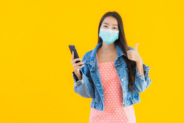 Retrato mulher jovem e bonita asiática usar máscara usar smartphone