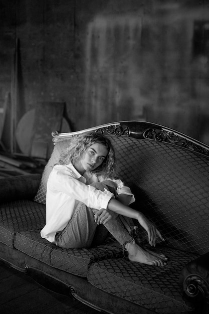 Foto grátis retrato preto e branco de uma linda mulher posando dentro de casa em um sofá