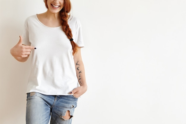 Foto grátis retrato recortado de uma adolescente europeia ruiva atraente com tatuagens