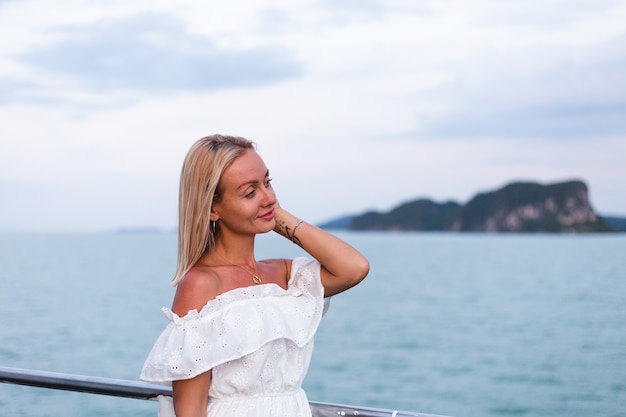 Retrato romântico de mulher de vestido branco navegando em uma grande balsa