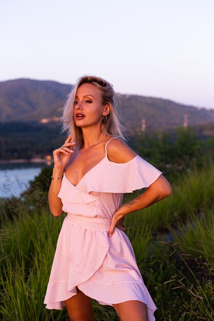 Retrato romântico de uma jovem mulher caucasiana com vestido de verão relaxando no parque na montanha com vista para o mar tropical. Mulher em viagens de férias pela Tailândia Mulher feliz ao pôr do sol