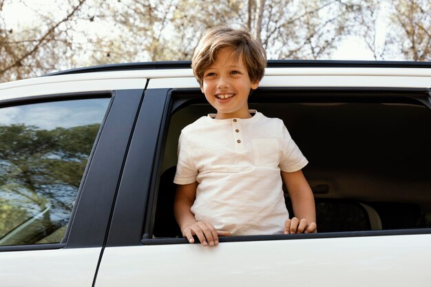 Foto grátis retrato sorridente de menino no carro