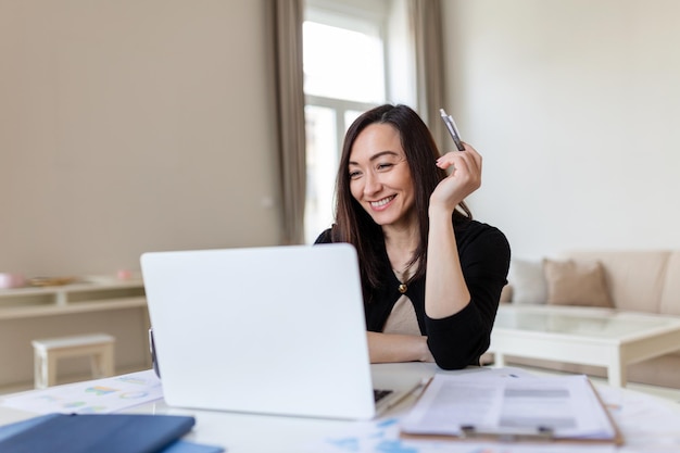 Retrato sorrindo linda mulher asiática de negócios trabalhando no computador virtual da mesa de escritório