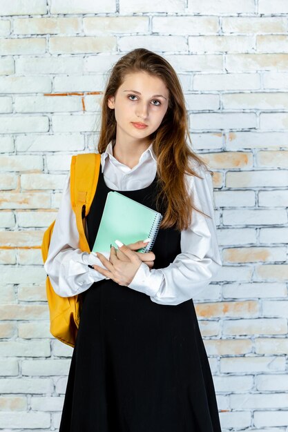 Retrato vertical de jovem estudante olhando para o objetivo