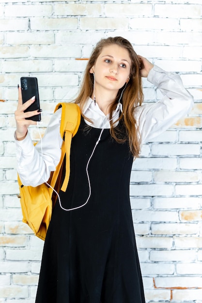 Retrato vertical de uma jovem estudante ouvindo música