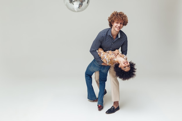 Foto grátis retrô amando o casal dançando perto de bola de discoteca.