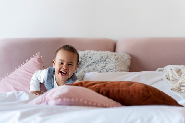 Foto grátis rindo bebê deitado na cama