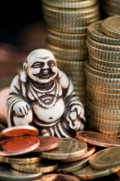 Rindo Budda na frente das moedas