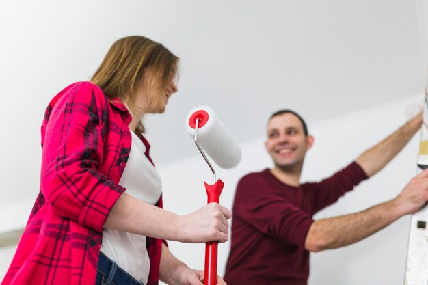 Foto grátis rindo casal com ferramentas de pintura