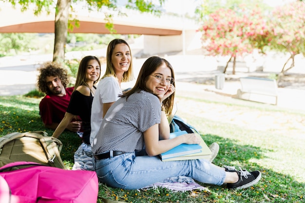 Rindo estudantes sentados no chão do parque