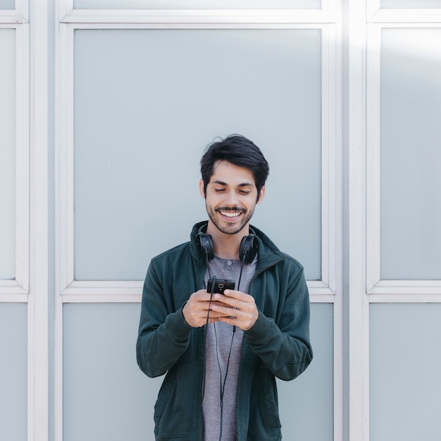 Foto grátis rindo homem com smartphone fora