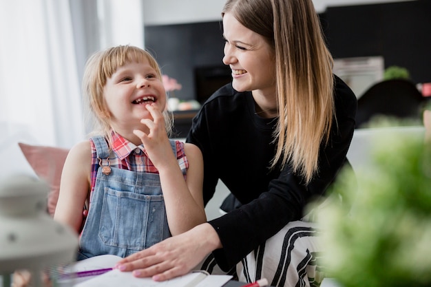 Rindo mãe e filha fazendo lição de casa