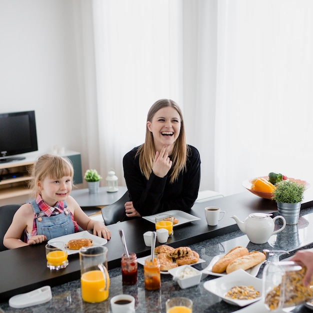 Foto grátis rindo mãe e filha tomando café da manhã