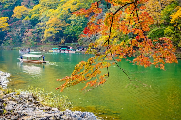 Rio Arashiyama bonito com árvore de folha de bordo e barco ao redor do lago
