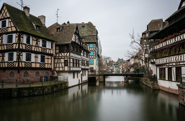 Rio cercado por edifícios na Petite France sob um céu nublado em Estrasburgo, na França