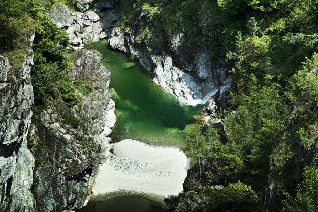 Rio cercado por grandes montanhas sob o sol