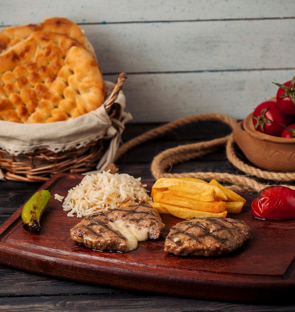 rissóis de carne recheados com queijo, servidos com batata frita, arroz, tomate e pimenta