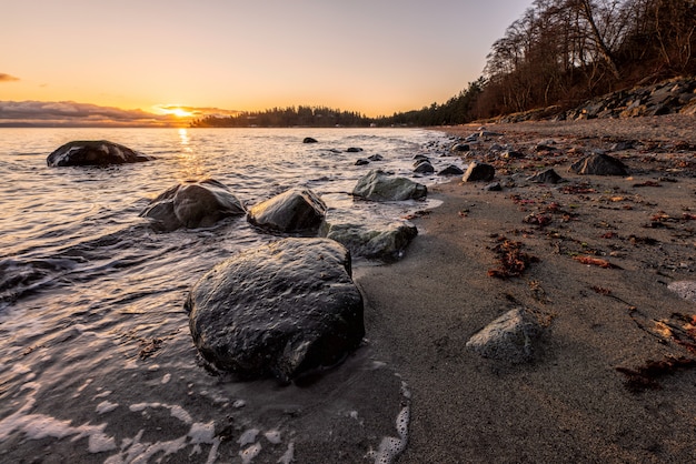 Rochas cinzentas na beira-mar durante o pôr do sol