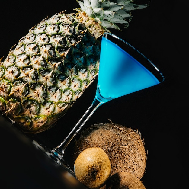Foto grátis rodar vista de cocktail e frutas exóticas em fundo preto