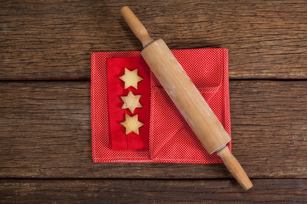 Rolar com biscoitos em forma de estrela em uma mesa de madeira