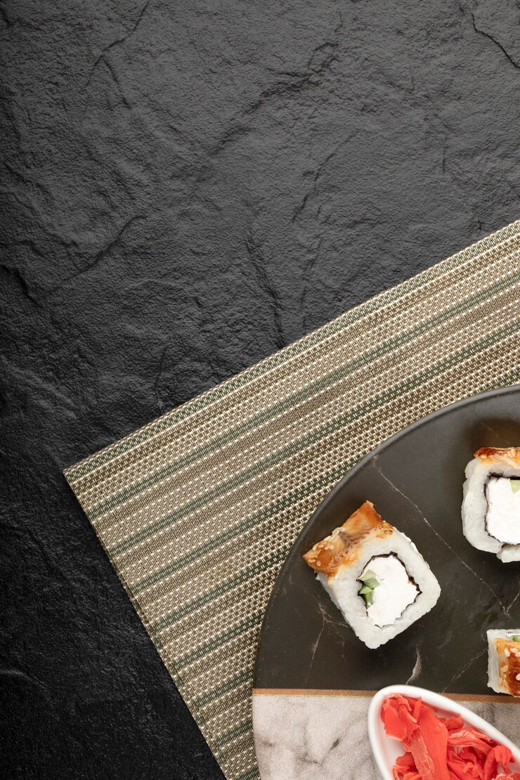 Foto grátis rolinhos de sushi de dragão com enguia e gengibre em conserva em prato de mármore