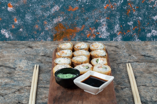 Rolinhos de sushi fritos quentes com molho de soja e wasabi.