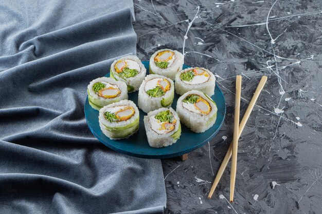 Rolinhos de sushi, molho de soja, wasabi e gengibre em conserva na mesa de pedra.