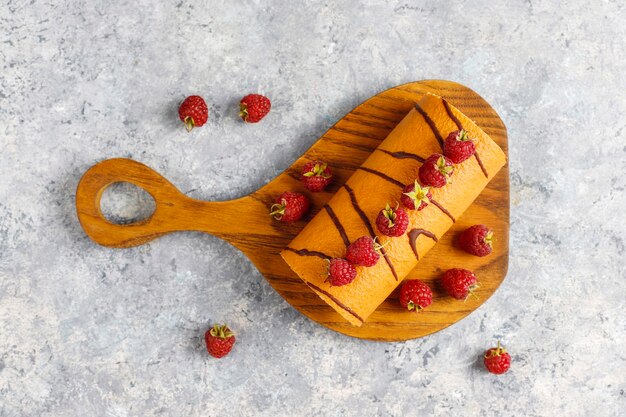 Rolo de bolo de framboesa com frutas frescas.