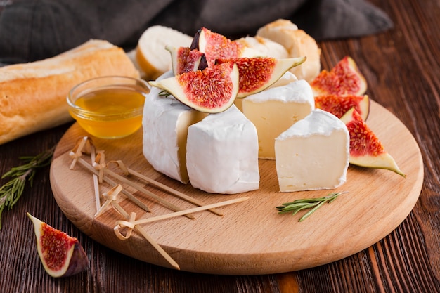 Rolo de camembert fatiado de alto ângulo com figo