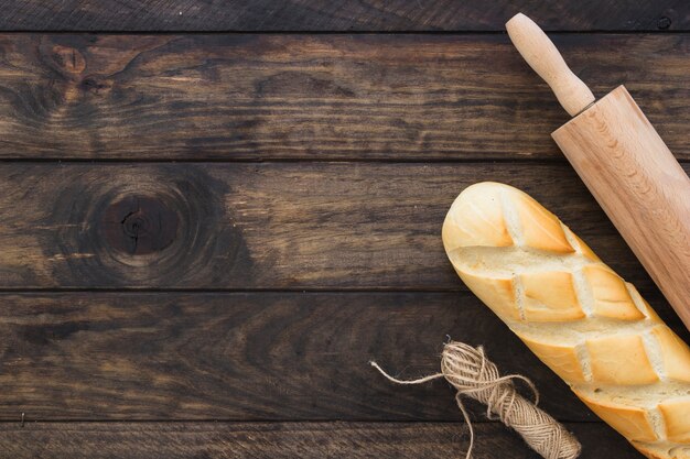 Rolo de massa e corda perto de pão