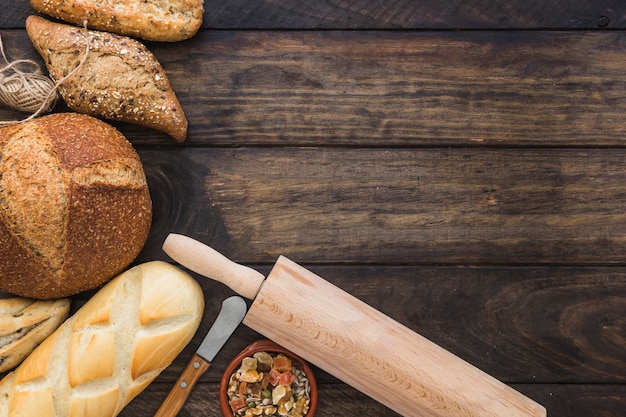 Rolo de massa e faca perto de pão