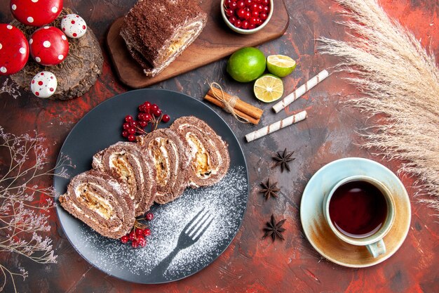 Rolos de biscoito gostoso com chá em fundo escuro, vista de cima