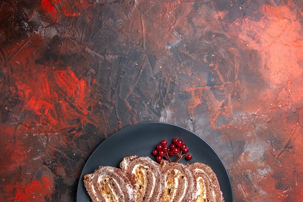 Rolos de biscoito gostosos com frutas no chão escuro