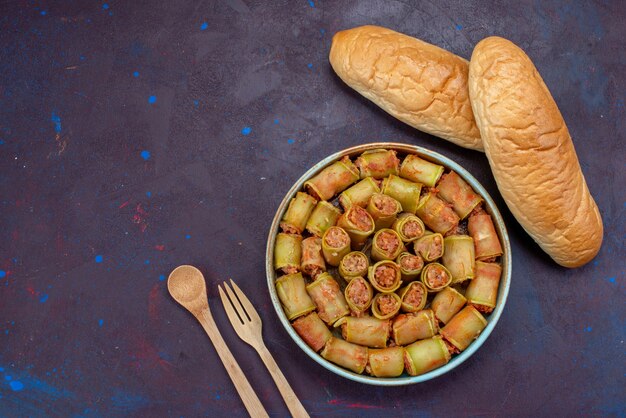 Foto grátis rolos de carne enrolados com legumes dentro da panela junto com pão na mesa escura carne jantar comida vegetal